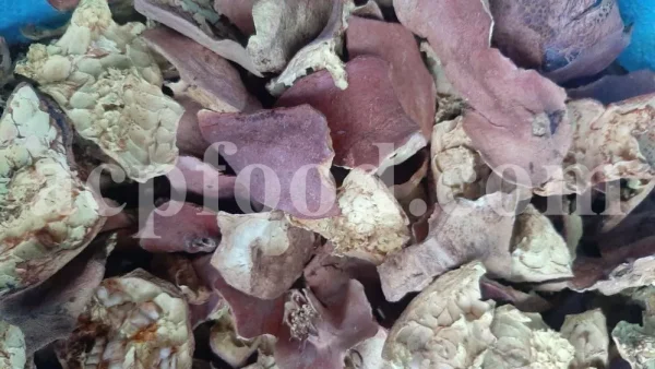 Dried pomegranate peel pieces showing reddish outer skin and cream-coloured inner pith