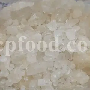 Bulk thymol crystals offered as Sat Ajwain, showing pale crystalline pieces inside a lined container